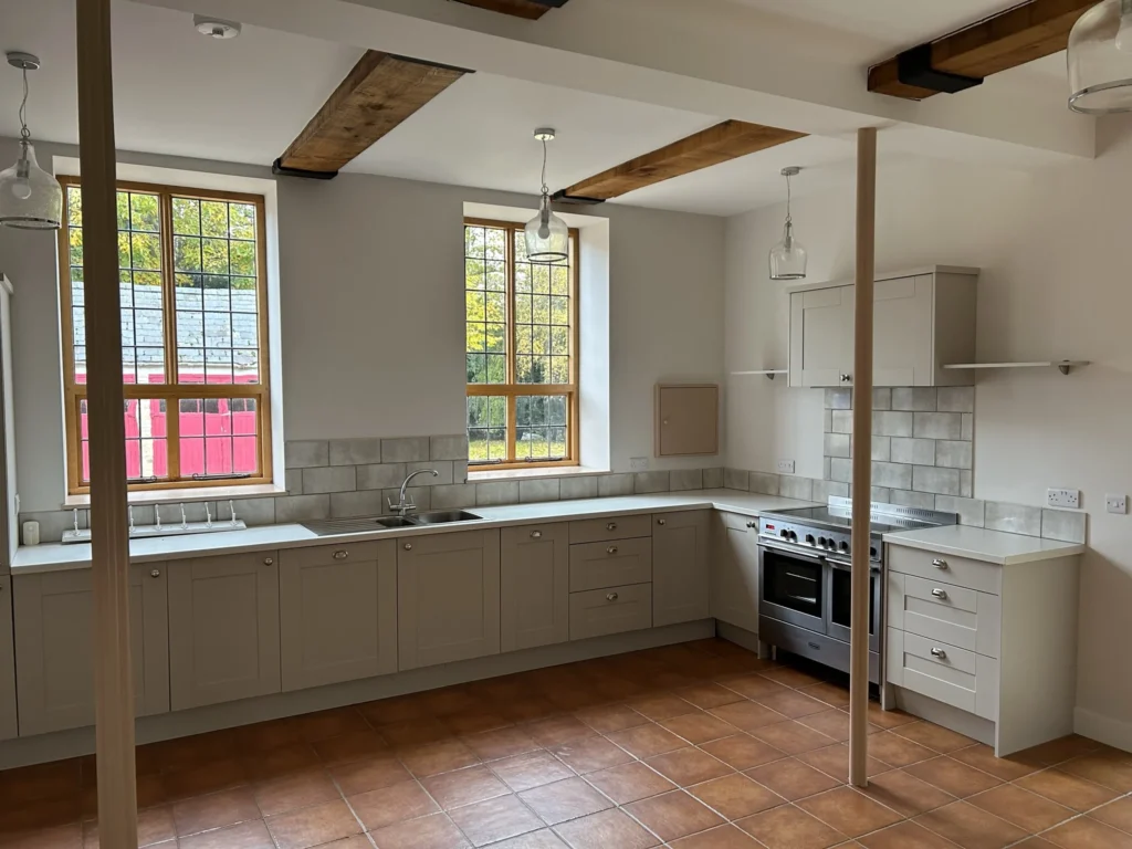 Kitchen extension inspiration: Shaker-style kitchen beneath exposed oak beams in a converted period building